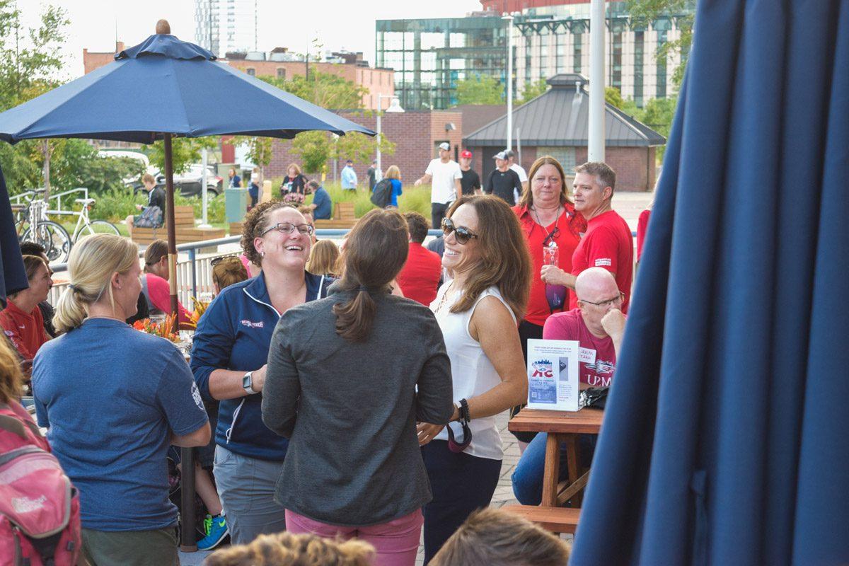 A group of people laughing at an event at the Tivoli Brewing Co. 水龙头的房子